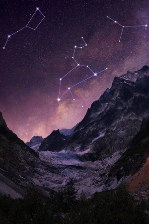 Different constellations in starry sky over mountains at nightの写真素材