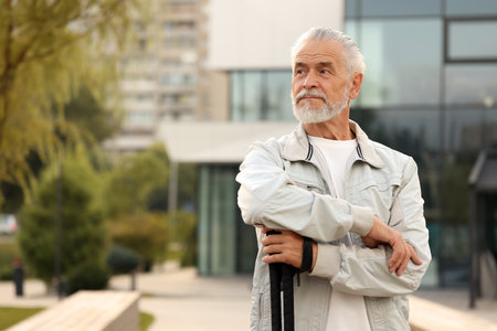 Senior man with Nordic walking poles outdoors, space for textの写真素材