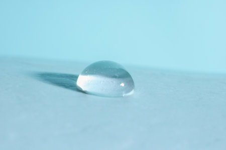 Macro photo of water drop on light blue background