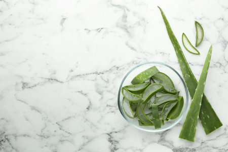 Fresh aloe vera pieces on white marble table, flat lay. Space for textの写真素材