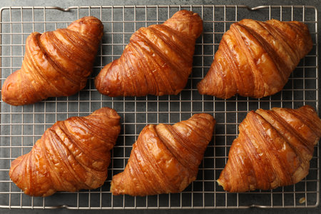 Delicious fresh croissants on gray table, flat lay