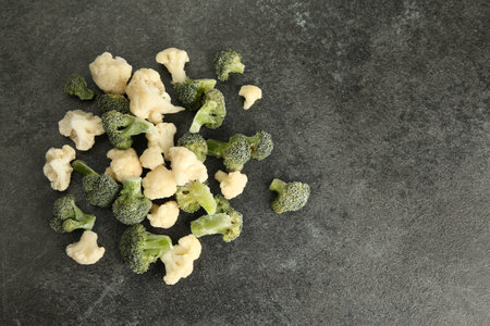 Frozen broccoli and cauliflower on gray table, top view. Space for textの写真素材