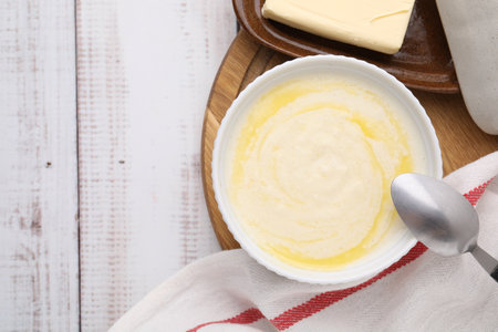 Bowl of delicious semolina pudding with butter served on table, top view. Space for textの写真素材