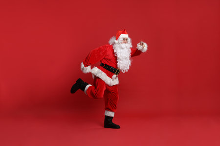 Merry Christmas. Santa Claus running on red backgroundの写真素材