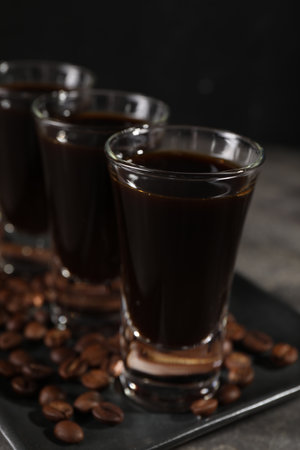 Shot glasses with coffee liqueur and beans on gray table, closeupの写真素材