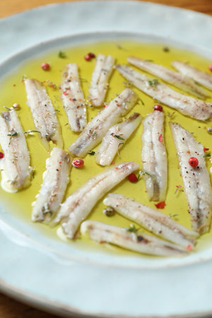 Tasty pickled anchovies with spices on plate, closeupの写真素材