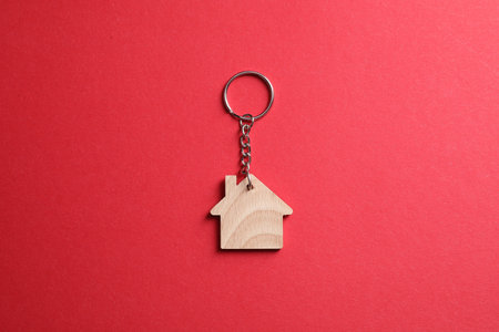 Wooden keychain in shape of house on red background, top viewの写真素材