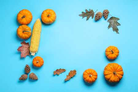 Thanksgiving day. Flat lay composition with pumpkins on light blue background, space for textの写真素材