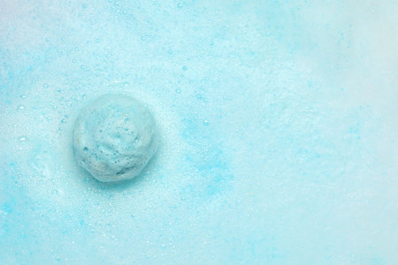 Light blue bath bomb dissolving in water. Space for textの写真素材