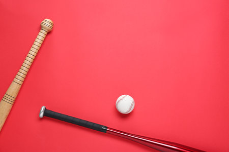 Baseball bats and ball on red background, flat lay. Space for textの写真素材