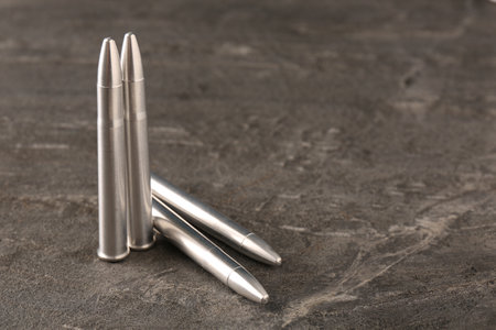Metal bullets on dark textured table, space for textの写真素材