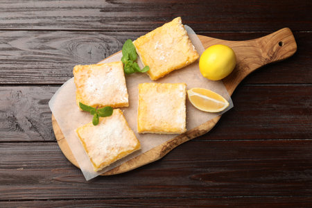 Tasty lemon bars powdered with sugar and mint on wooden table, top viewの写真素材