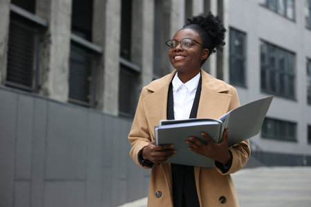 Happy woman with folders outdoors, space for text. Lawyer, businesswoman, accountant or manager