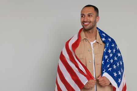 4th of July - Independence Day of USA. Happy man with American flag on light gray background, space for textの写真素材