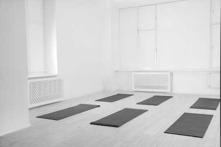 Spacious yoga studio with exercise mats on floorの写真素材