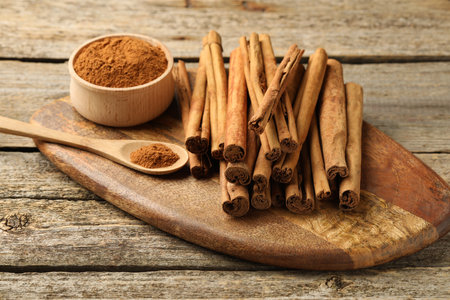 Cinnamon powder and sticks on wooden tableの写真素材