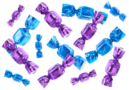 Tasty candies in bright wrappers falling on white backgroundの写真素材