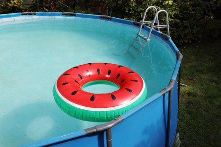 Inflatable ring floating on water in above ground swimming pool outdoorsの写真素材