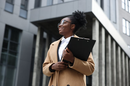 Happy woman with clipboard outdoors. Lawyer, businesswoman, accountant or managerの写真素材