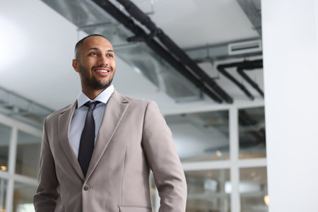 Happy man with crossed arms in office, space for text. Lawyer, businessman, accountant or manager