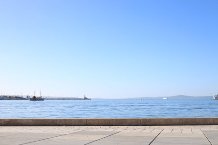 Beautiful view of embankment and calm sea with yachts on sunny day