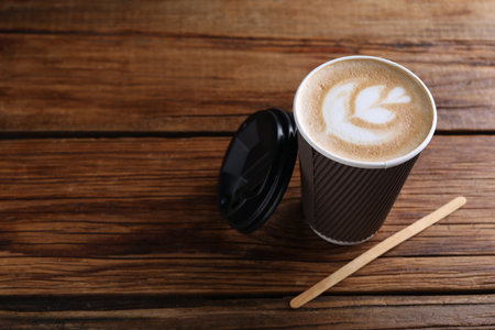 Coffee to go. Paper cup with tasty drink on wooden table, space for textの写真素材
