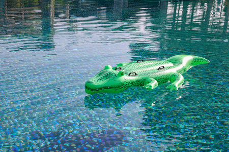 Float in shape of crocodile in swimming pool outdoorsの写真素材