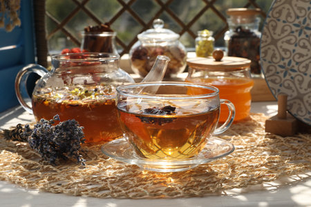 Aromatic tea with different dry plants and honey on white tableの写真素材