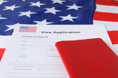 Immigration to USA. Visa application form and passport on flag, closeupの写真素材