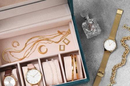 Jewelry box with many different accessories and perfume on light gray table, flat layの写真素材