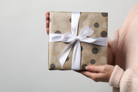 Christmas present. Woman holding gift box against white background, closeup. Space for text