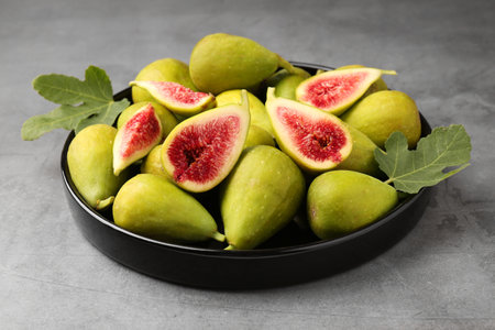 Cut and whole green figs on light gray table, closeupの写真素材