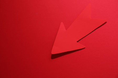 One paper arrow on red background, top view. Space for textの写真素材