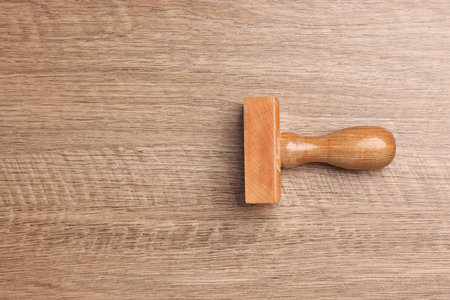 One stamp tool on wooden table, top view. Space for textの写真素材