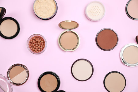 Different face powders on pink background, flat layの写真素材