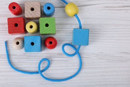 Wooden lacing toy on light table, top view and space for text. Motor skills developmentの写真素材