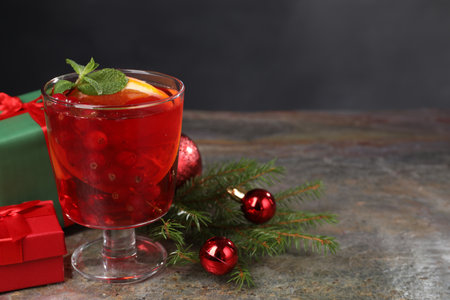 Aromatic Christmas Sangria in glass, gift boxes and festive decor on gray textured table, space for textの写真素材