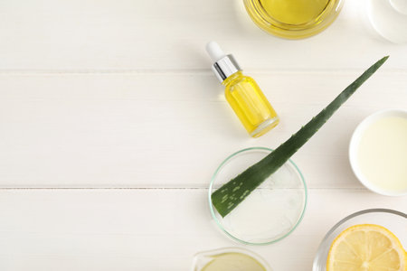 Flat lay composition with bottle of cosmetic oil on white wooden table, space for textの写真素材