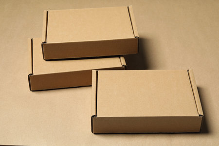 Many closed cardboard boxes on light brown backgroundの写真素材