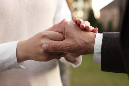 Trust and deal. Partners joining hands outdoors, closeupの写真素材