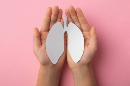 Child holding paper human lungs on pink background, top viewの写真素材