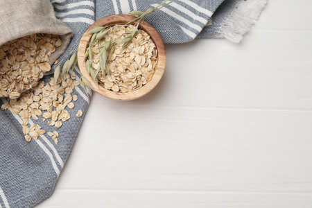 Oatmeal and florets on white wooden table, flat lay. Space for textの写真素材