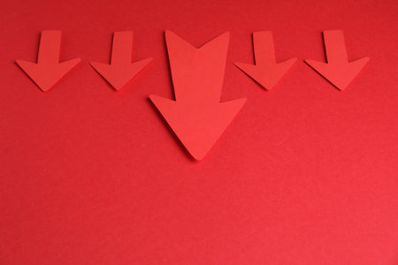Many paper arrows on red background, above view. Space for textの写真素材