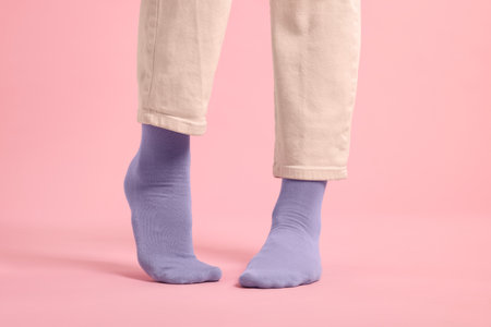 Woman in stylish purple socks and pants on pink background, closeupの写真素材