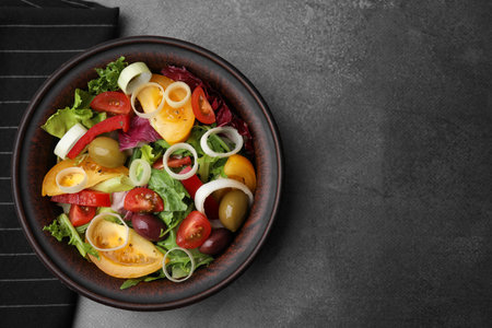 Bowl of tasty salad with leek and olives on brown table, top view. Space for textの写真素材