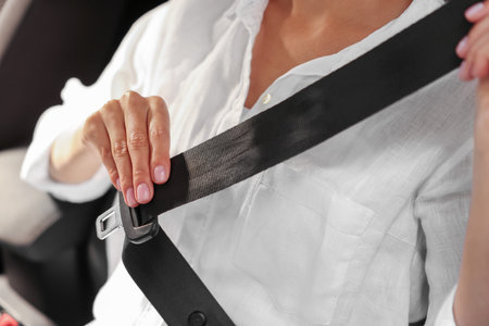 Woman pulling seat belt in car, closeupの写真素材