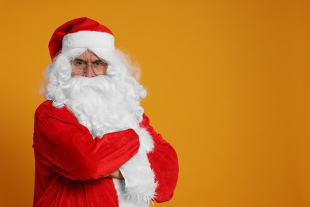 Merry Christmas. Angry Santa Claus on orange background, space for textの写真素材