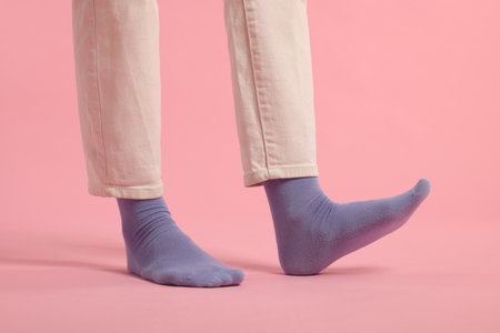 Woman in stylish purple socks and pants on pink background, closeupの写真素材
