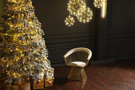 Beautiful decorated Christmas tree, chair and festive decor indoors, space for text. Interior designの写真素材