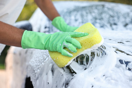 Man washing car with sponge outdoors, closeupの写真素材